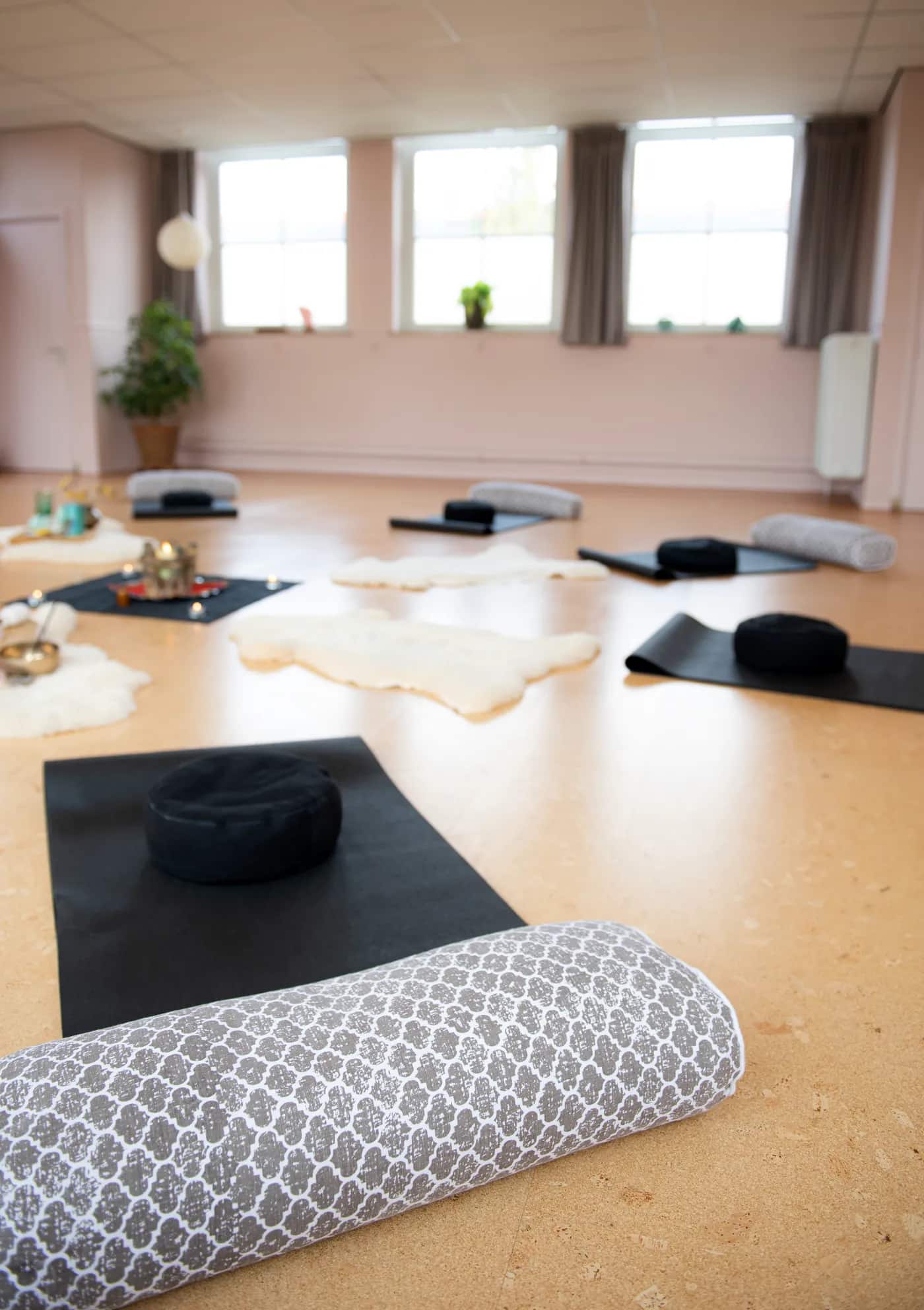 Matten en een bolster klaargelegd voor een workshop in de yogazaal